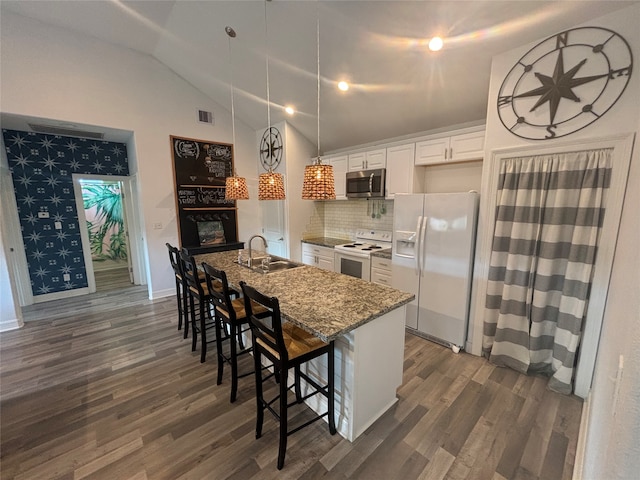 kitchen with light stone counters, white cabinetry, white appliances, a breakfast bar area, and lofted ceiling