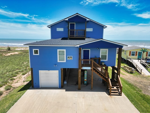 view of front of home featuring a garage, a water view, and a view of the beach