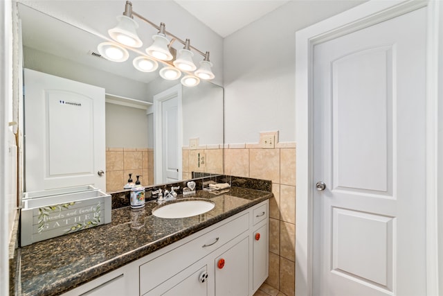 bathroom featuring vanity and tile walls