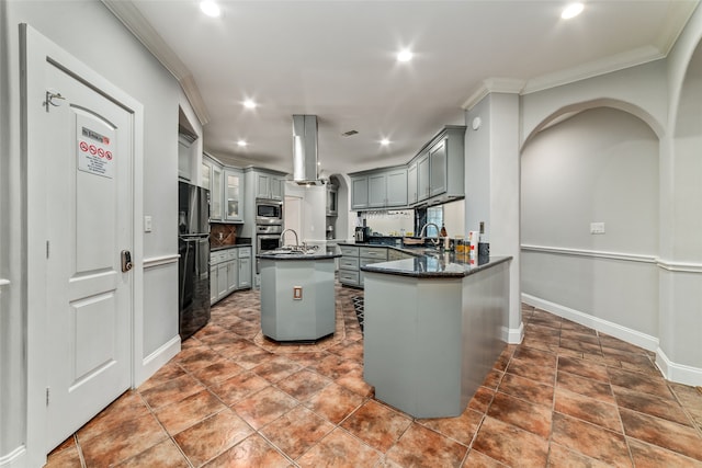 kitchen featuring ornamental molding, stainless steel appliances, an island with sink, and gray cabinetry