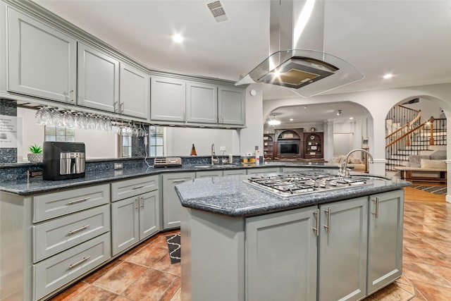 kitchen with gray cabinets, sink, and island range hood