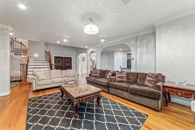 living room with an inviting chandelier, hardwood / wood-style flooring, and ornamental molding