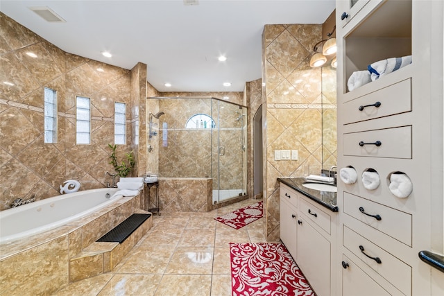 bathroom with vanity, shower with separate bathtub, a healthy amount of sunlight, and tile walls