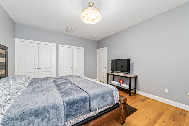 bedroom featuring multiple closets and wood-type flooring