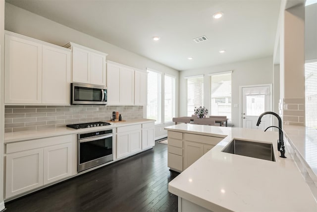 kitchen featuring stainless steel appliances, dark hardwood / wood-style flooring, white cabinets, sink, and tasteful backsplash