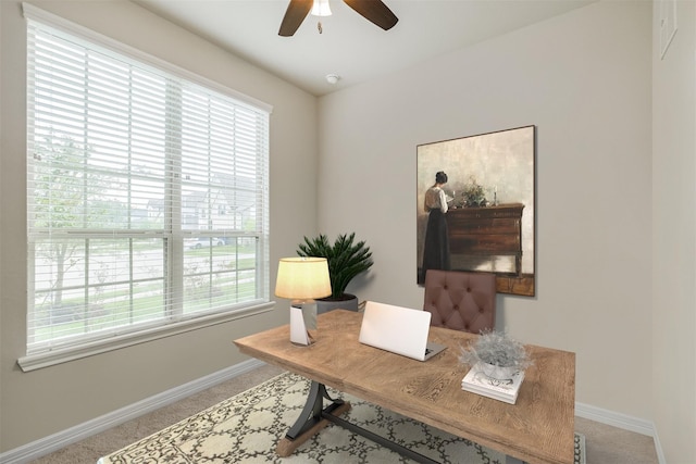 carpeted office featuring plenty of natural light and ceiling fan