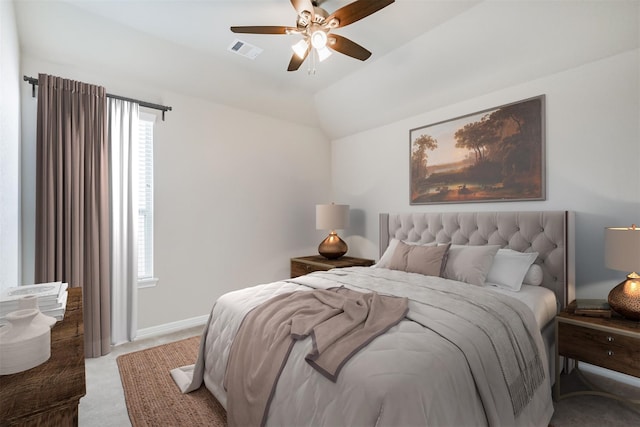 carpeted bedroom featuring ceiling fan, multiple windows, and vaulted ceiling