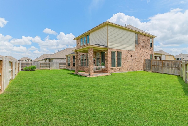 rear view of property featuring a yard and a patio area