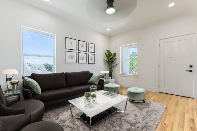 living room featuring light wood-type flooring and ceiling fan