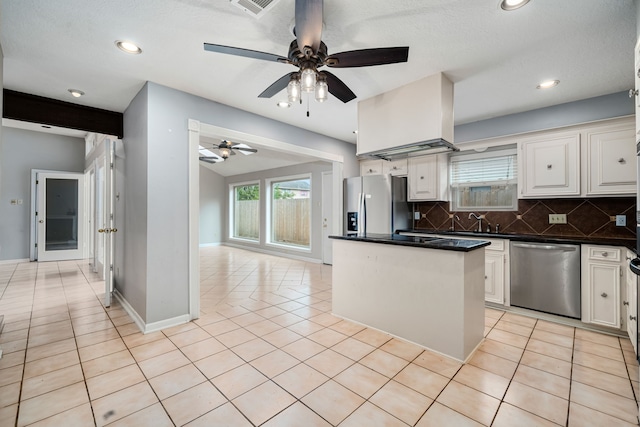 kitchen featuring ceiling fan, decorative backsplash, appliances with stainless steel finishes, light tile patterned flooring, and white cabinetry