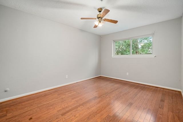 spare room featuring hardwood / wood-style flooring, ceiling fan, and a textured ceiling