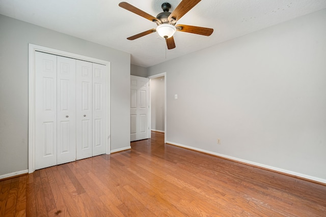 unfurnished bedroom featuring light wood-type flooring, a closet, and ceiling fan