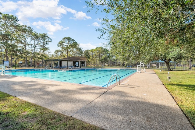 view of swimming pool featuring a patio area and a yard