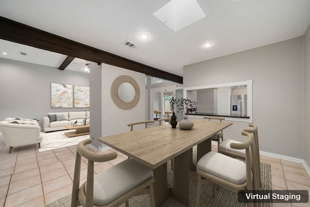 dining space featuring ceiling fan, beam ceiling, light tile patterned floors, and a skylight