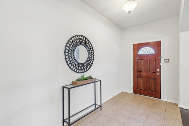 entryway with light tile patterned floors and lofted ceiling