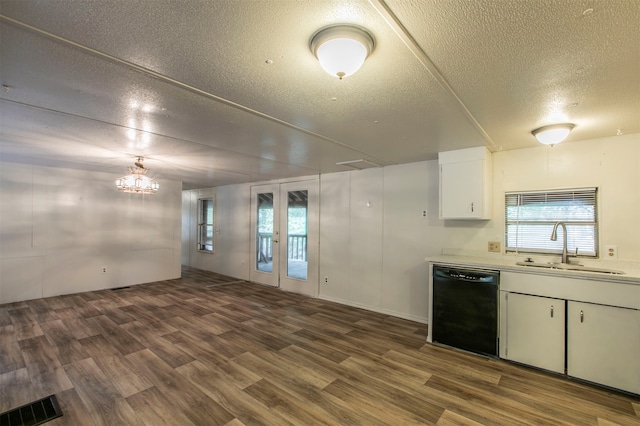 kitchen featuring a textured ceiling, black dishwasher, sink, hardwood / wood-style flooring, and white cabinets