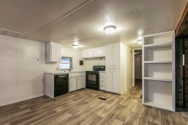 kitchen featuring light hardwood / wood-style floors, white cabinetry, sink, black appliances, and a textured ceiling