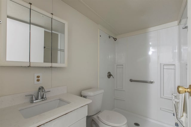 bathroom with toilet, a shower, and vanity