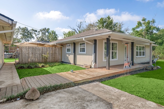 back of property featuring covered porch and a yard