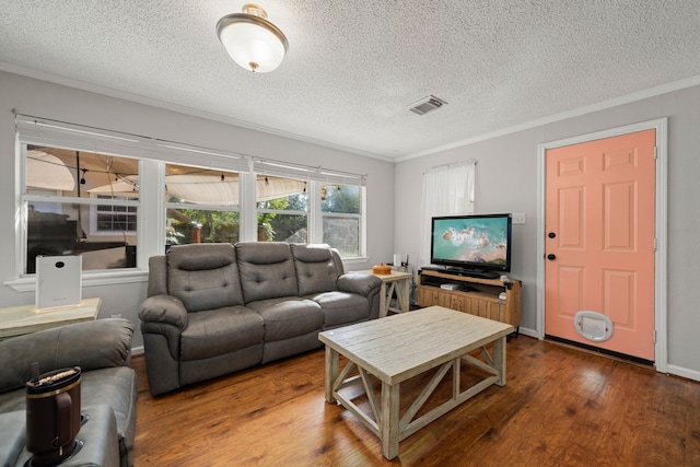 living room featuring wood-type flooring, a textured ceiling, and crown molding