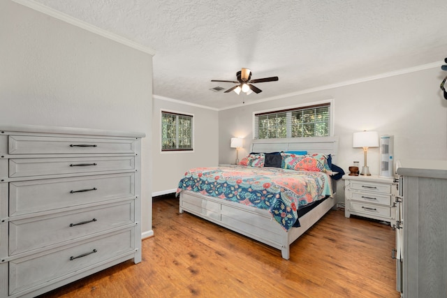 bedroom featuring ceiling fan, a textured ceiling, light hardwood / wood-style flooring, and crown molding