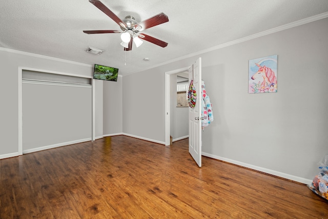 unfurnished bedroom featuring ornamental molding, a textured ceiling, hardwood / wood-style flooring, and ceiling fan