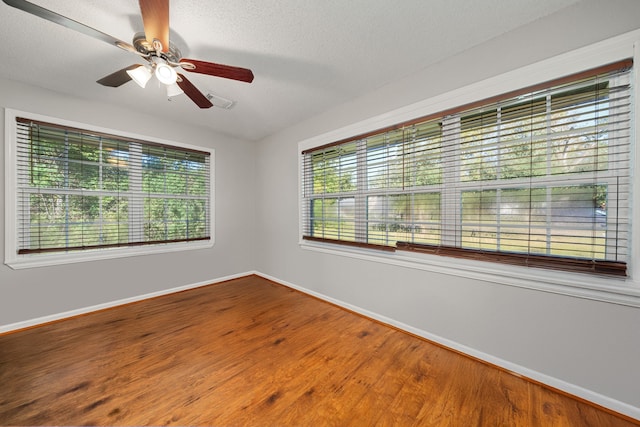 spare room featuring hardwood / wood-style flooring, ceiling fan, and a textured ceiling