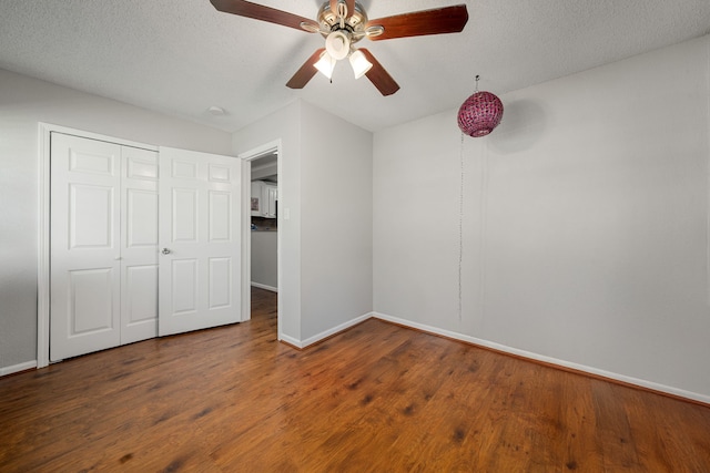 unfurnished bedroom with dark wood-type flooring, a closet, a textured ceiling, and ceiling fan