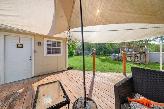 wooden deck featuring a playground and a yard