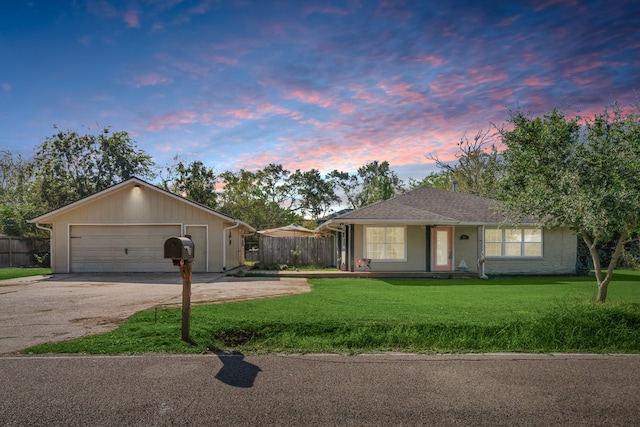 ranch-style home featuring a garage and a yard