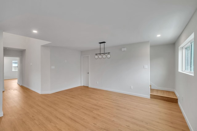 spare room featuring a wealth of natural light and light hardwood / wood-style flooring