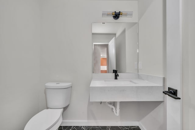 bathroom featuring tile patterned flooring, toilet, and sink