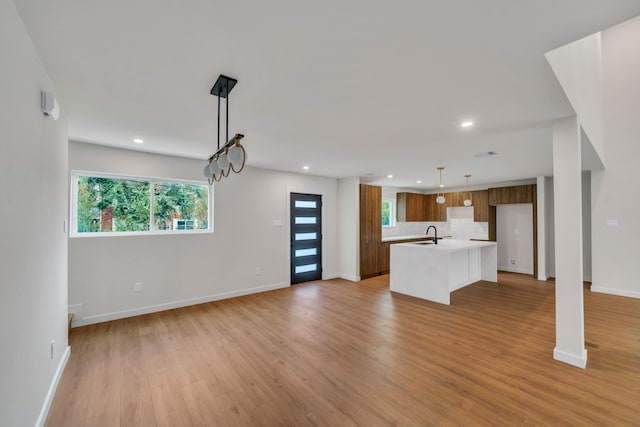 unfurnished living room featuring sink and light wood-type flooring