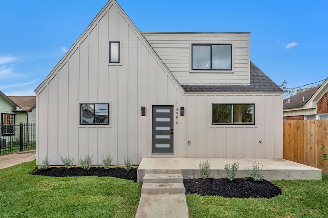 modern farmhouse style home with a front yard