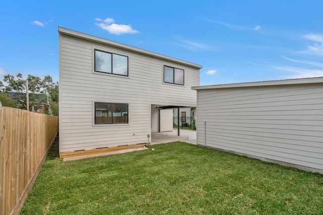 rear view of property featuring a patio area and a lawn