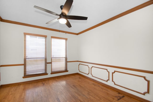 empty room with ornamental molding, hardwood / wood-style floors, and ceiling fan