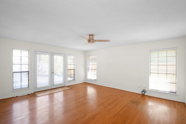 unfurnished room featuring ceiling fan, french doors, a healthy amount of sunlight, and light hardwood / wood-style flooring