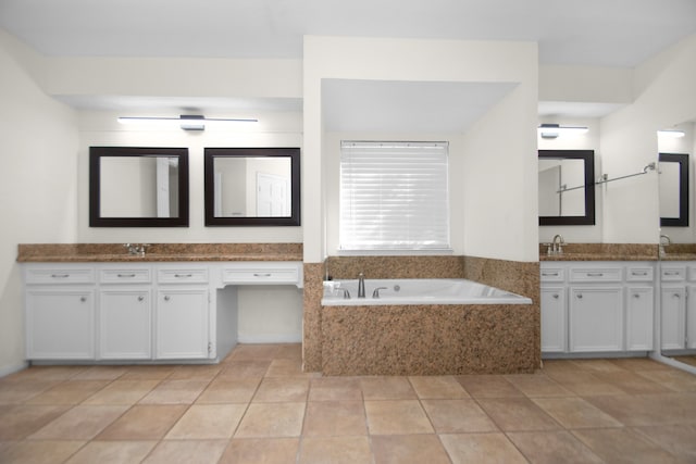 bathroom with vanity, tile patterned flooring, and tiled tub