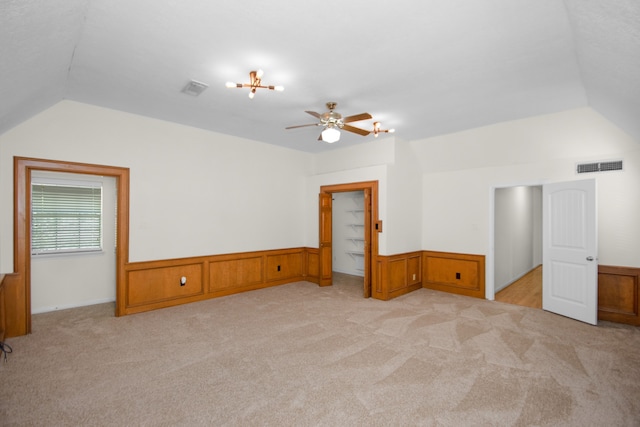 carpeted empty room featuring lofted ceiling and ceiling fan