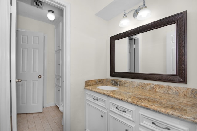 bathroom featuring toilet, vanity, and tile patterned floors