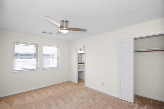 unfurnished bedroom featuring a closet, light colored carpet, and ceiling fan