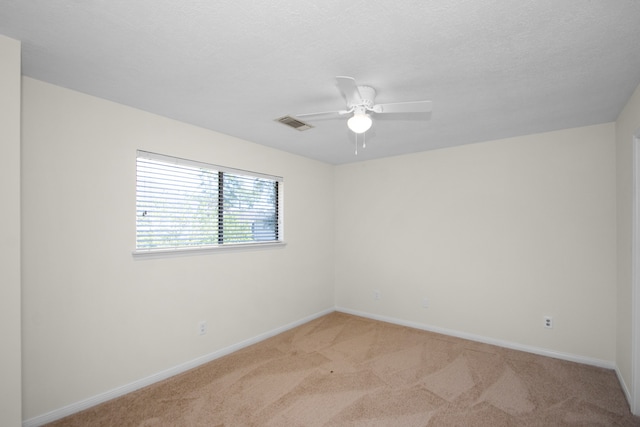 carpeted spare room with ceiling fan and a textured ceiling