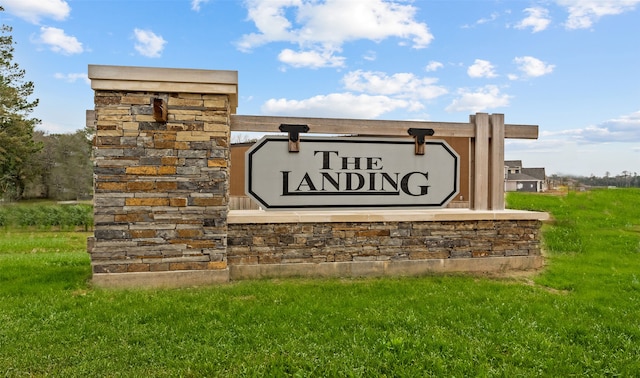 community sign featuring a yard