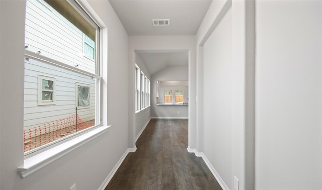 hallway with lofted ceiling and dark hardwood / wood-style floors