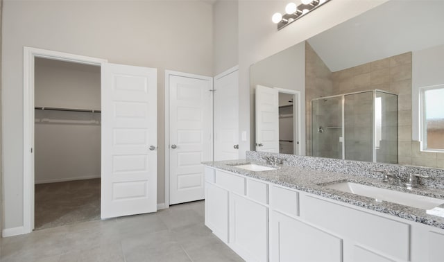 bathroom featuring a shower with door, vanity, tile patterned flooring, and high vaulted ceiling