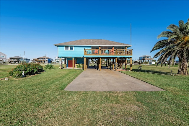 rear view of property with a carport, a yard, and a wooden deck