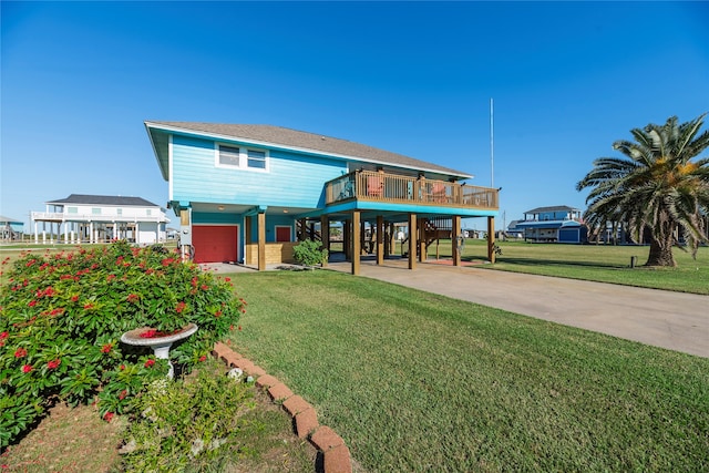 view of front of house with a wooden deck, a carport, a front yard, and a garage