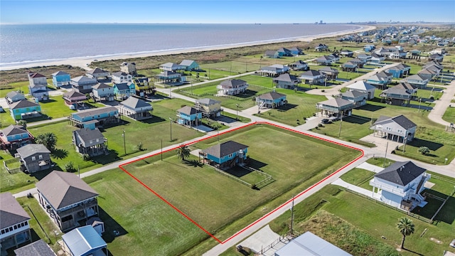 aerial view with a water view and a beach view