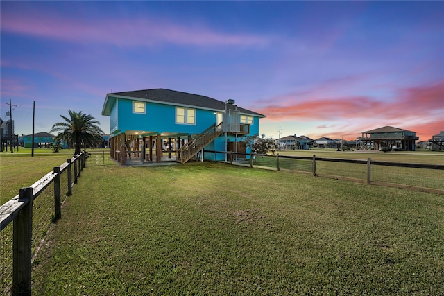 back house at dusk with a lawn