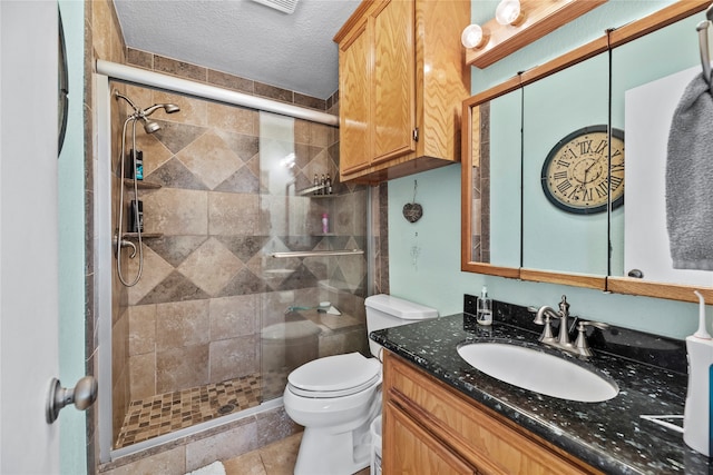 bathroom with vanity, tile patterned flooring, toilet, a textured ceiling, and walk in shower